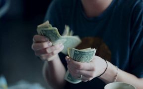 Focus Photography Of Person Counting Dollar Banknotes