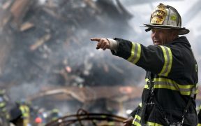 fire fighter wearing black and yellow uniform pointing for 70573