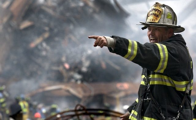 Fire Fighter Wearing Black And Yellow Uniform Pointing For 70573