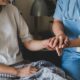 A Nurse Holding A Patient'S Hand Description Automatically Generated With Low Confidence